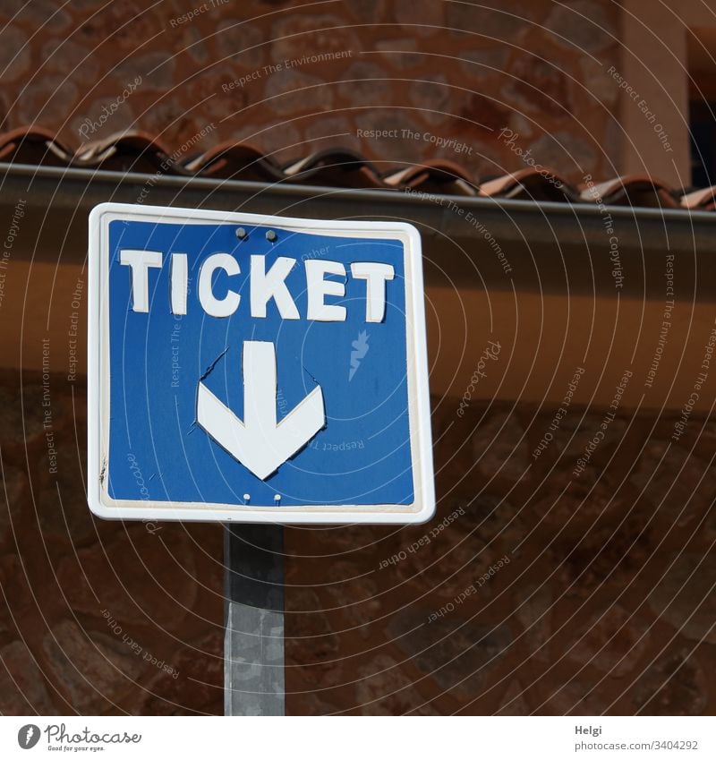 Ticket, Hinweisschild mit Pfeil nach unten vor einer Wand Schilder & Markierungen Außenaufnahme Fahrschein Verkehr blau weiß braun menschenleer quadratisch