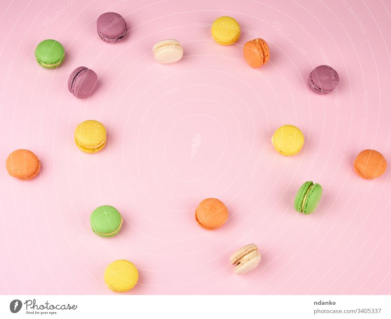 viele mehrfarbige runde gebackene Makronenkuchen auf einem hellrosa Hintergrund Mandel sortiert Sortiment Bäckerei Biskuit Kuchen Bonbon Nahaufnahme Farbe