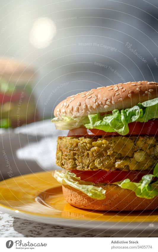 Hausgemachter veganer grüner Linsen-Burger Burger gesundes Essen vertikal Fastfood Vegane Ernährung natürlich selbstgemacht Lebensmittel Tomate Salat