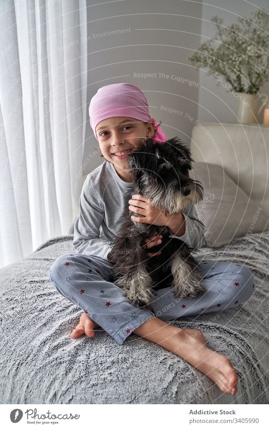 Süßes kleines Kind spielt mit Hund auf dem Bett spielen krank Junge Streicheln Haustier heimwärts züchten Therapie Tier männlich Hilfsbereitschaft Glaube Liebe