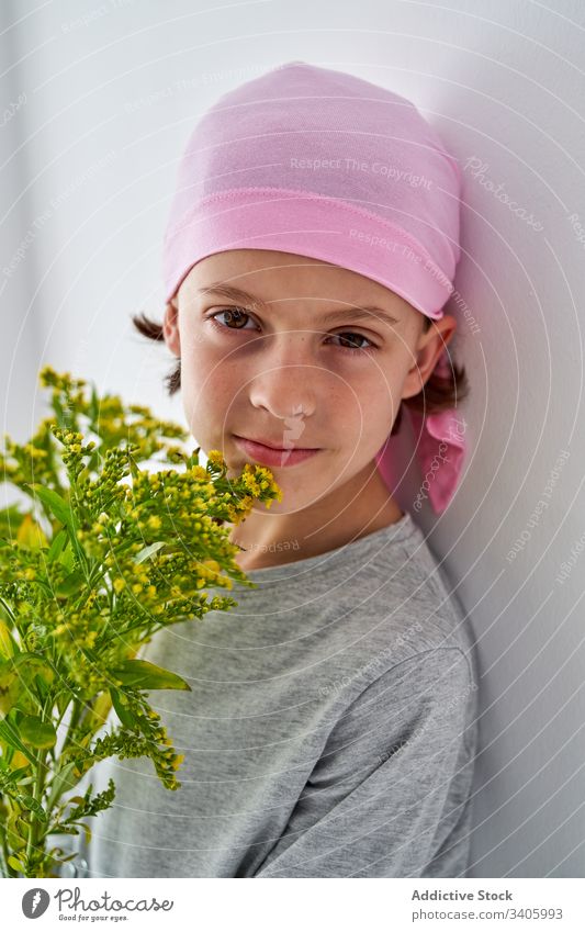 Glückliches niedliches Kind mit Blumen an der Wand Krebs Diagnostik Vase Pflanze Junge krank kämpfen klein männlich geduldig mutig Krankheit gegen Erkenntnis
