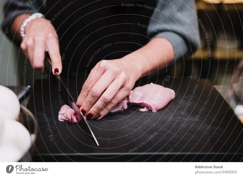 Erntehelfer beim Schneiden von Hühnerbrust Person geschnitten Hähnchen Tisch Küche Restaurant Koch Kurs Messer vorbereiten frisch Küchenchef Bestandteil Prozess
