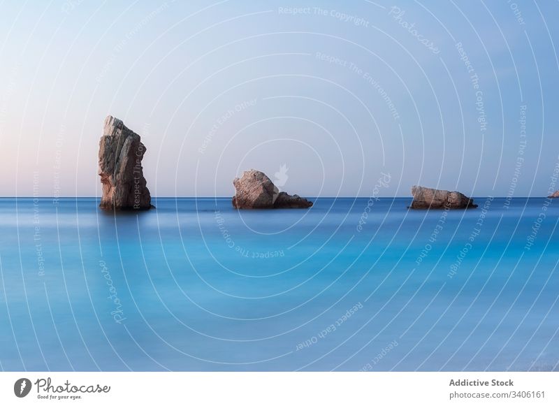 Felsenküste und friedliches Meer bei Sonnenuntergang Ufer MEER Steine Himmel wolkenlos Landschaft niu de s'aguila Ibiza Spanien Wasser Natur Küste Windstille