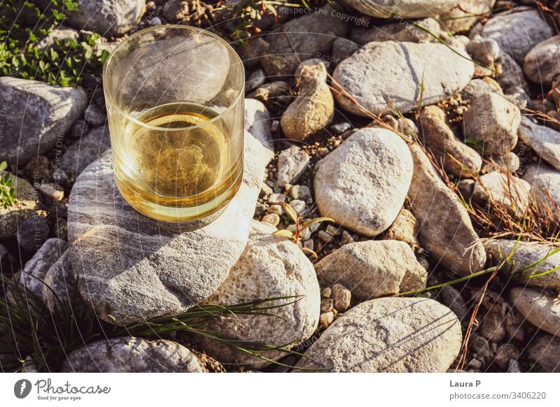 Nahaufnahme eines Glases mit Whisky auf einigen Steinen abschließen Whiskey Rum Alkohol Getränk Bourbon trinken Natur Konzept sich[Akk] entspannen Erholung