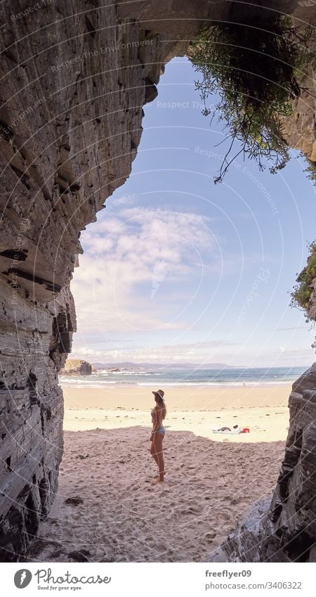 Junge Frau betrachtet eine Höhle aus Felsen in Galicien, Spanien Tourismus wandern Galicia Ribadeo Castros Illas atlantisch Bucht touristisch Kathedralen Klippe