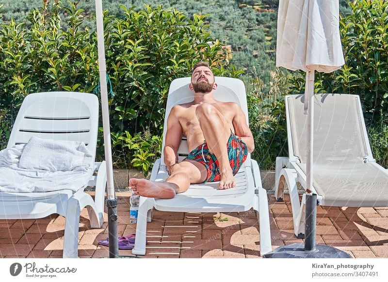 Hübscher bärtiger Mann sonnen sich auf einem Liegestuhl und genießt die Sommerzeit Freizeit Bräune männlich Person sonnig Kaukasier ruhen Erholung Pool Lügen