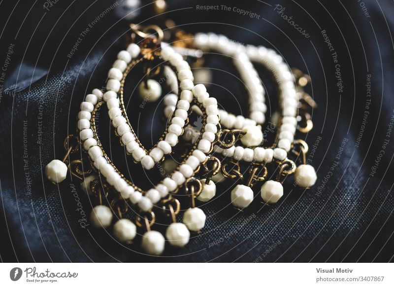 Nahaufnahme eines Paares von Ohrringen im ethnischen Stil mit weißen Perlen abstrakte Fotografie Kunst Kunst und Handwerk schön Boho Boho-Stil schick