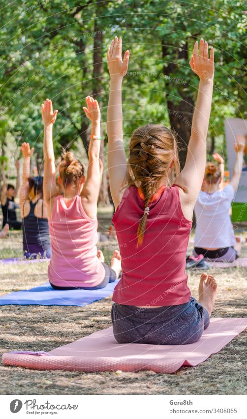 Yoga in einem Park eine Gruppe von Menschen, die auf Yogamatten sitzen und die Asana hell Windstille Klasse Farbe Veranstaltung Übung Mädchen Menschengruppe