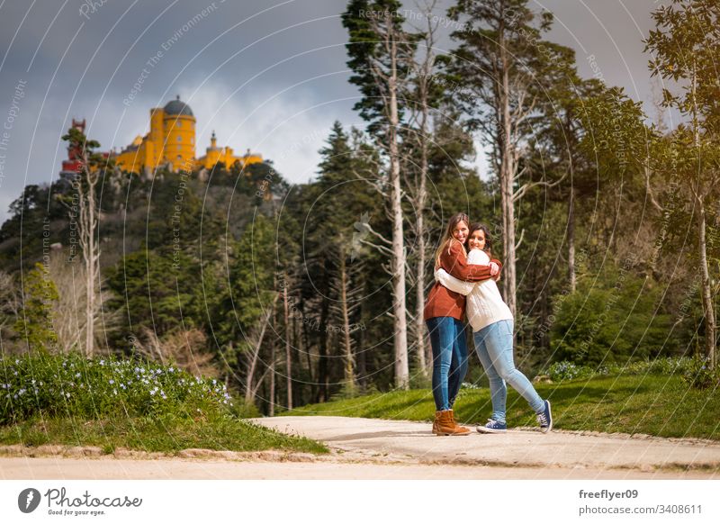 Zwei Freunde umarmen sich vor dem Pena-Palast in Sintra, Portugal Gebäude national Wahrzeichen europa Historie traditionell Baum Antiquität Berge u. Gebirge