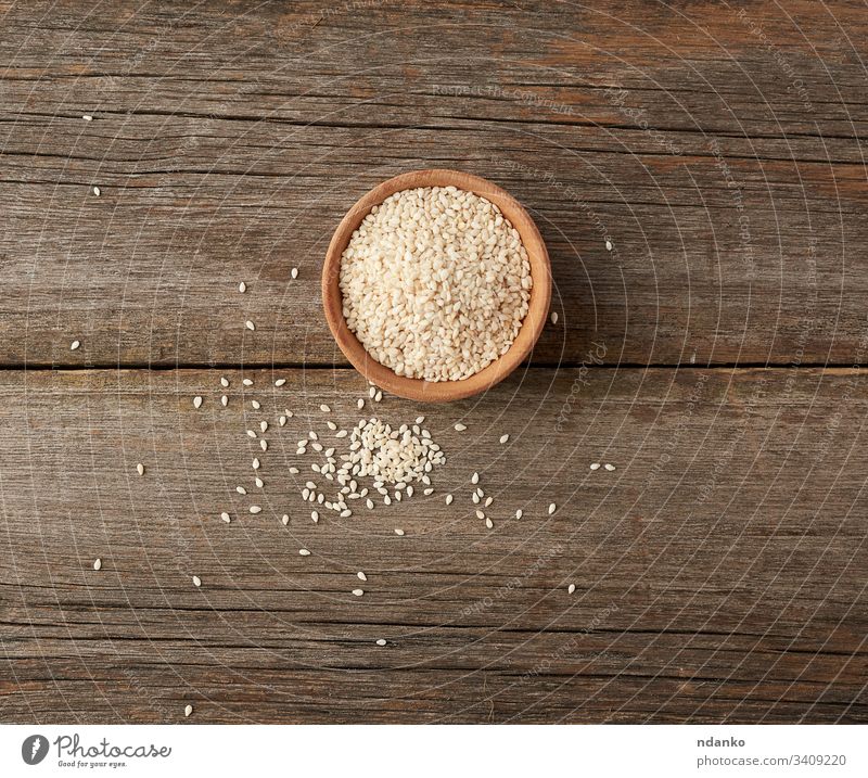 trockene weiße Sesamkörner in einer braunen Holzschüssel Schalen & Schüsseln Lebensmittel Samen Hintergrund organisch Bestandteil hölzern Gesundheit Vegetarier