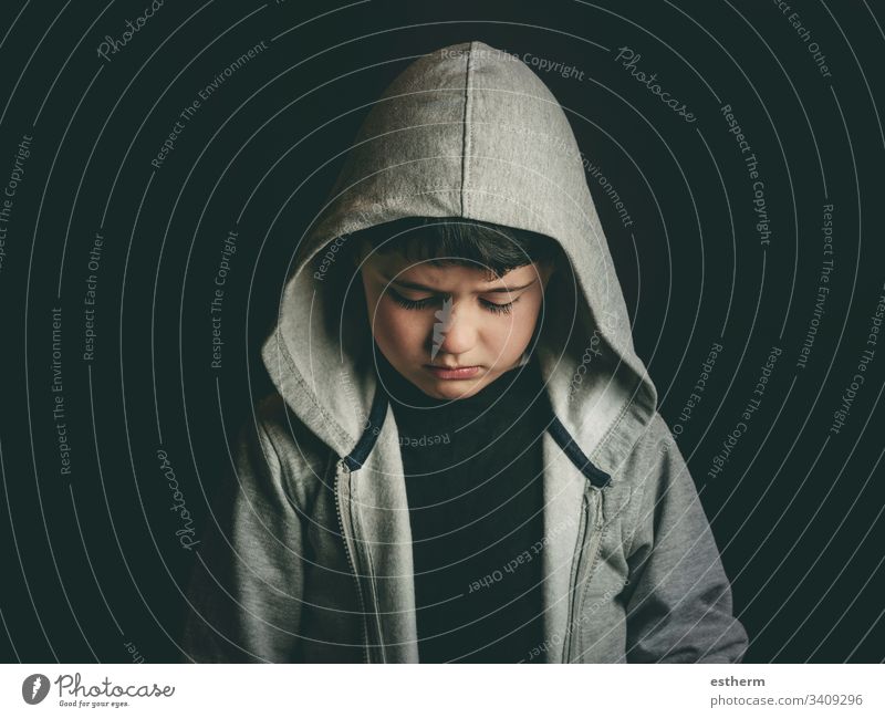 Trauriger Junge auf schwarzem Hintergrund Kind traurig niedergeschlagen Angst unglücklich Mobbing vereinzelt Depression Bildung Stress Opfer Trennung