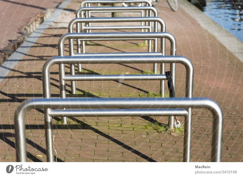 Fahrradständer fahrradständer fahrräder bike aufbewahren anlehnen abstellen parkplatz parken geländer stahlrohr metall niemand textfreiraum