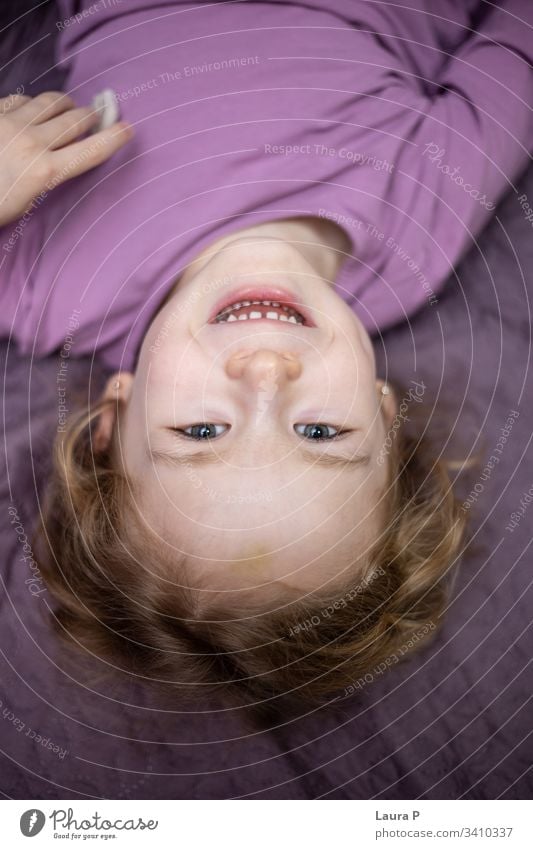 Glückliches kleines Mädchen im Schlafanzug, das im Bett spielt nach unten Kleinkind Lachen Erholung Morgen im Innenbereich Vorschule Tochter bezaubernd Kopf