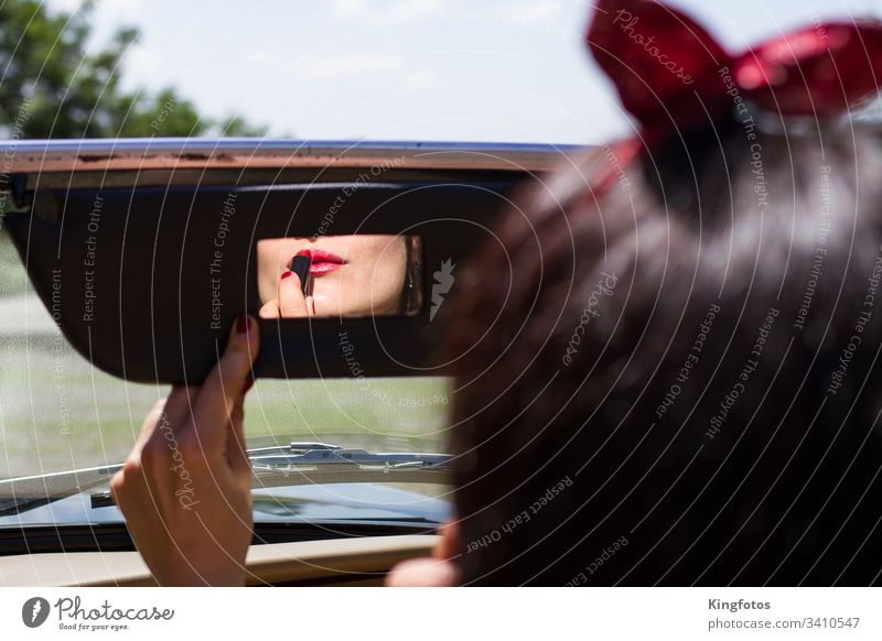 Frau zieht Lippenstift im Auto nach rot Vintage Rückspiegel Autospiegel Schminke Spiegel Cabrio Hand Fingernägel Nagellack Querformat sinnlich Lippenpflege