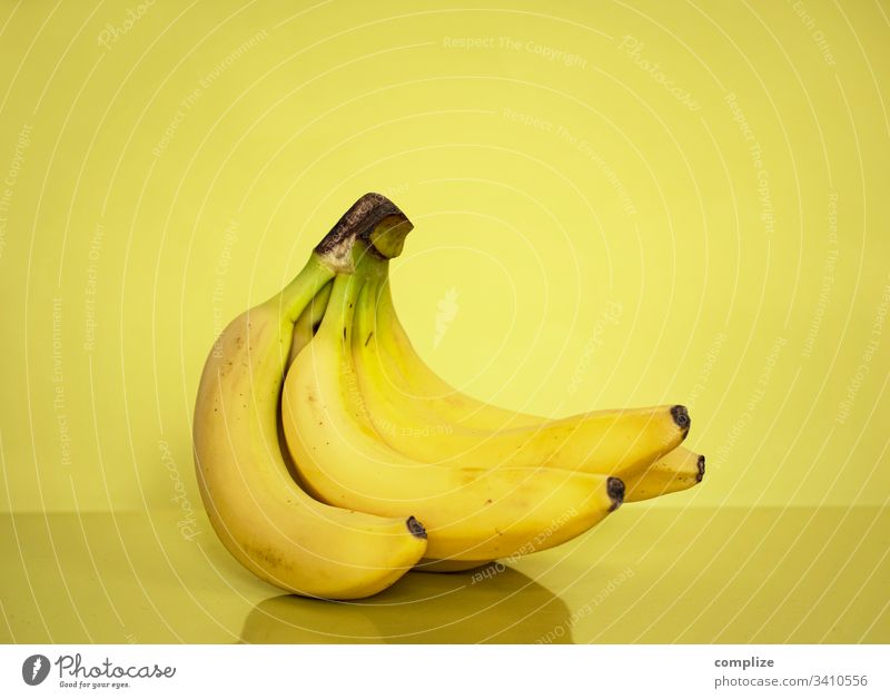 gelbe Bananen vor gelben Hintergrund Gesunde Ernährung Obst- oder Gemüsestand obst früchte südfrucht frisch markt vitamine