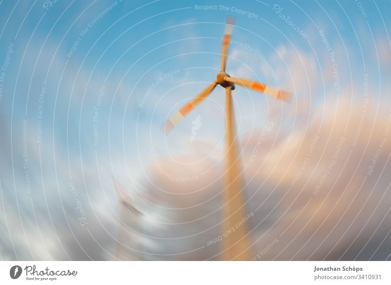 ökologisches Windkraftwerk mit erneuerbarer grüner Energie auf einem Feld in der Abendsonne alternativ Hintergrund blau Unschärfe Wandel & Veränderung