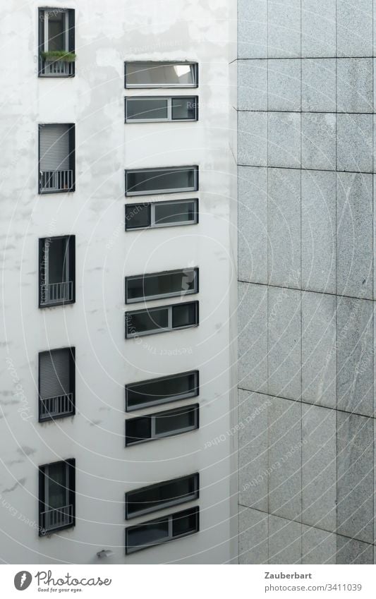 Fassade eines Hochhauses mit Fenstern im Hoch- und Querformat sowie Granitplatten in lichtem Grau Haus Architektur grau lichtgrau trist Fensterrahmen Quarantäne