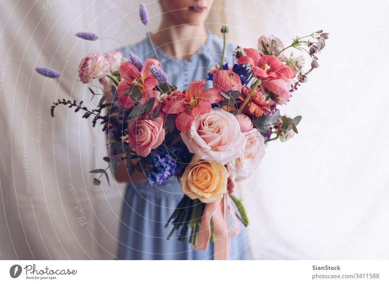 Junge Frau in einem hellblauen Kleid mit einem Blumenstrauß in der Hand. Romantisches Konzept. Mädchen weiches Licht schön altehrwürdig Hochzeit weiß jung