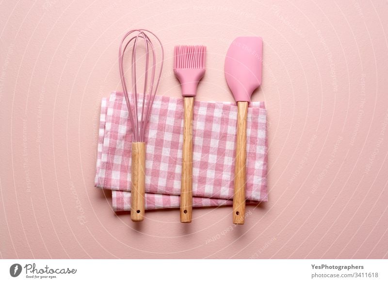 Küchenutensilien auf einem rosa Tisch. Bunte Backwerkzeuge backen Sauberkeit farbenfroh Konzept Essen zubereiten flache Verlegung Haushalt Küchengeräte