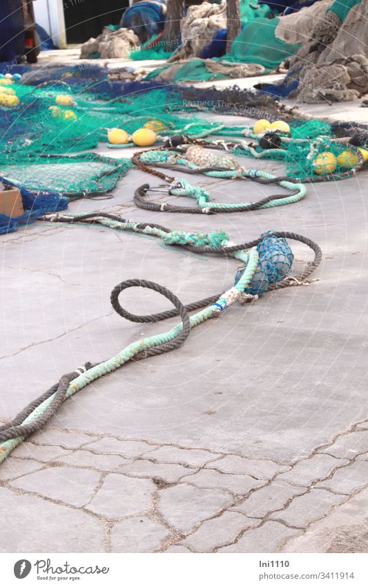 Seilschaft | bunte Fischernetze mit dicken farbigen Seilen und Fischerkugeln liegen auf Kaimauer Meeresfarben Taue ausbreiten blau türkis gelb Schlaufe