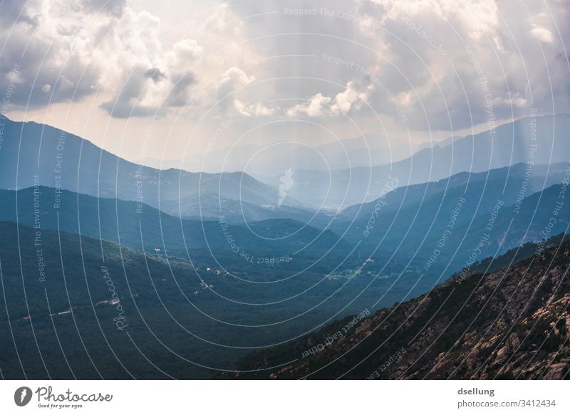 Aussicht auf mehrere Ebenen von Bergen mit Sonnenstrahlen bei bewölktem Himmel Schönes Wetter Expedition Klimawandel Umwelt blau Panorama (Aussicht) Licht