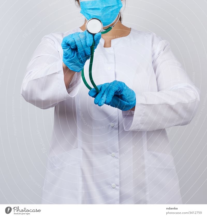 Medizinerin in weißem Mantel und Maske, mit blauen medizinischen Latexhandschuhen Erwachsener Pflege Kaukasier prüfen Klinik Konzept Arzt Gerät Frau Mädchen