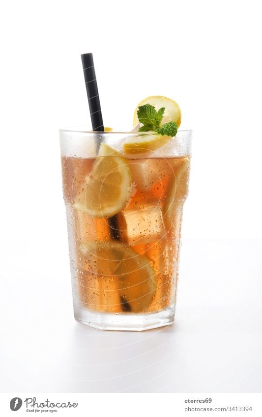 Eisteegetränk im Glas mit isolierter Zitrone auf weißem Hintergrund Getränk braun Zitrusfrüchte Cocktail kalt trinken frisch Frucht vereinzelt liquide Minze