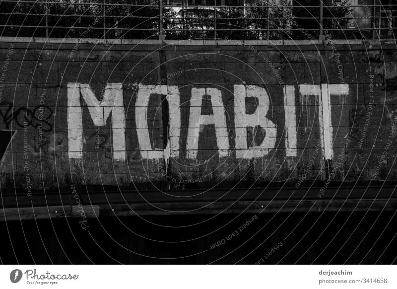 Markanter Schriftzug am Kanal in  Großen Buchstaben in Weiß. MOABIT. Schriftzeichen Dinge weiß Kommunizieren Sprache Wort schwarz Menschenleer Kommunikation