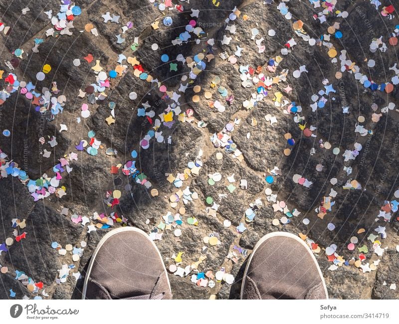 Pflaster mit buntem Konfetti und Schuhen bedeckt Karneval feiern Straße Textur abstrakt Feiertag Farbe Straßenbelag Straßenfotografie urban Detailaufnahme oben