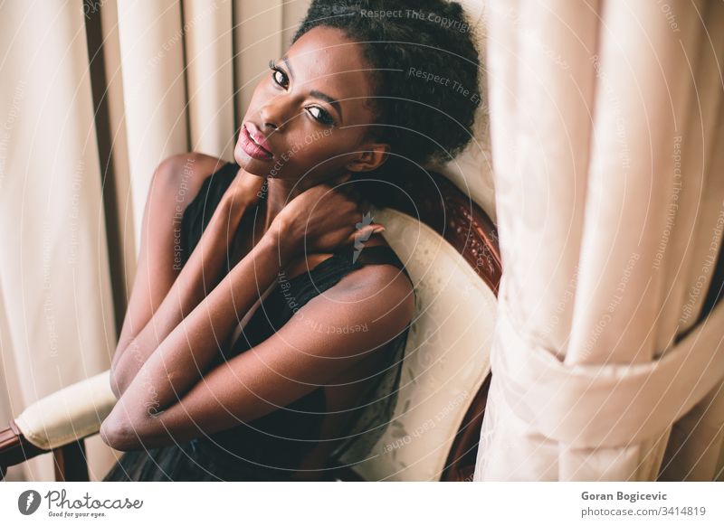 Junge schwarze Frau im Raum Afro-Look Ethnizität Windstille Erwachsener sitzen Mädchen heimwärts Amerikaner charmant Stuhl Freizeit attraktiv Gelassenheit