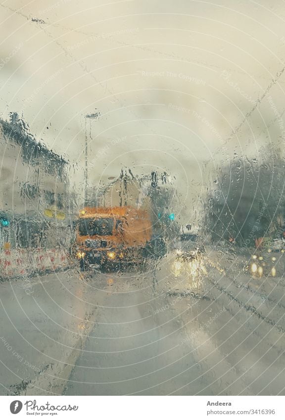 Verschwommene nasse Straße mit Autos und leuchtenden Scheinwerfern im Regenwetter Himmel Regenhimmel Licht Laterne Haus Reflexion Lampe PKW Stadt Verkehr