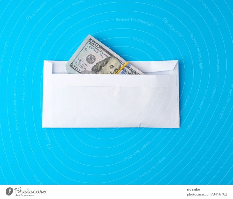 Packung Papier Amerikanische Hundert-Dollar-Scheine, die mit einem Gummiband gebunden sind und in einem weißen Umschlag liegen Geld Kuvert Business Finanzen
