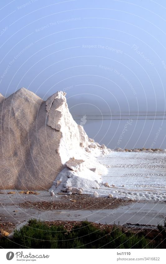abgetragener Salzberg mit Einblick auf das weiße Salz im Hintergrund die Saline im bläulichem Morgennebel Salzgewinnung Mittelmeer altes Handwerk Industriezweig