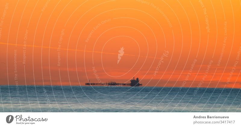 Frachtschiff fährt bei Tagesanbruch reisen Horizont Boot Wasser niemand MEER orange Morgendämmerung Transport Ladung Landschaft Schiff Spedition Silhouette