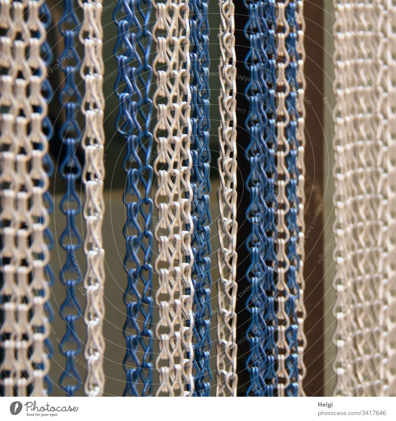 herabhängende weiße, graue und blaue Ketten als Vorhang an einer Tür Kettenglied Kettenvorhang Sichtschutz Metall Außenaufnahme menschenleer Detailaufnahme