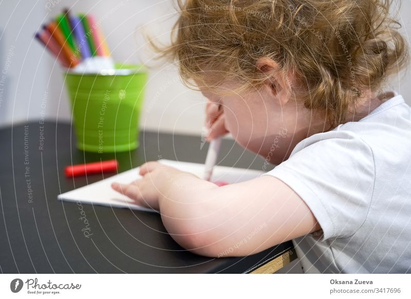 Ein Mädchen ist Wittling. Schreibwaren bunte Schreibgeräte, Zubehör, Filzstifte, farbiges Papier, Bücher. Hausunterricht Coronavirus Heimunterricht