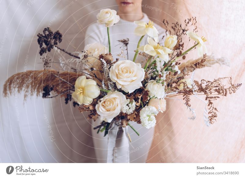 Junge Frau in einem weißen Kleid mit einem Blumenstrauß in der Hand. Vintage, romantisches Konzept. Mädchen weiches Licht schön altehrwürdig Hochzeit jung