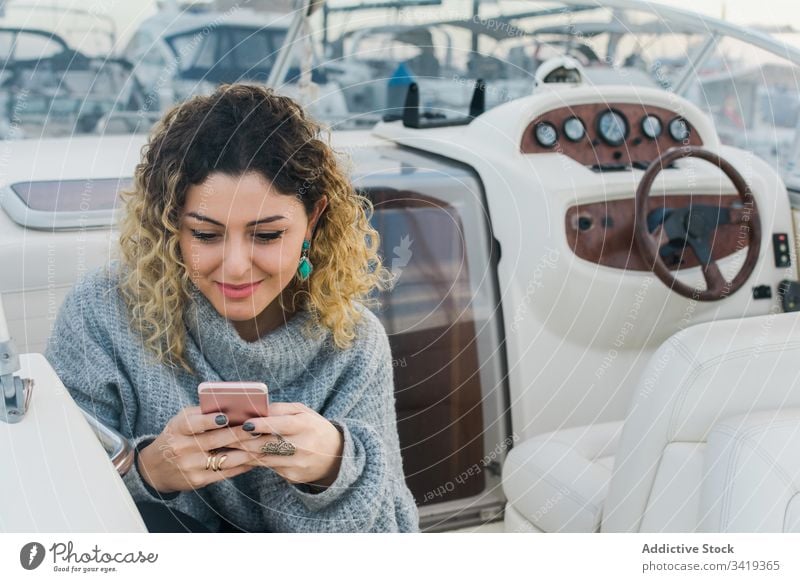 Zufriedene Dame mit Smartphone auf Yacht Frau benutzend Jacht Lächeln Browsen Handy Lachen zufrieden Inhalt genießen Surfen zuschauen Anschluss Gerät Apparatur