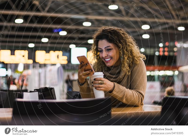 Frau beim Kaffeetrinken und am Mobiltelefon am Flughafen Smartphone Telefon Getränk Tasse lässig zum Mitnehmen Funktelefon modern sich[Akk] entspannen Pause