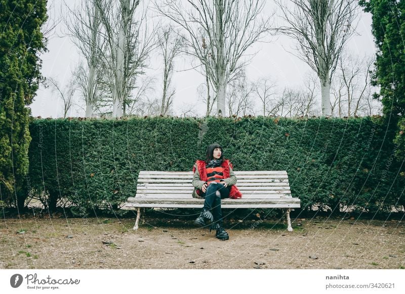 Junge Frau entspannt sich im Winter in einem grünen Park jung im Freien Einsamkeit allein Natur natürlich kalt Jugend frisch wirklich offen ruhen aussruhen