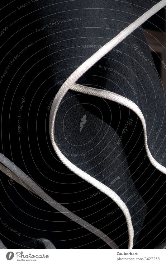 Schwarzer Sonnenschirm mit weißen Streifen, gefaltet, in Nahaufnahme schwarz Falten Strukturen & Formen Linie abstrakt Menschenleer