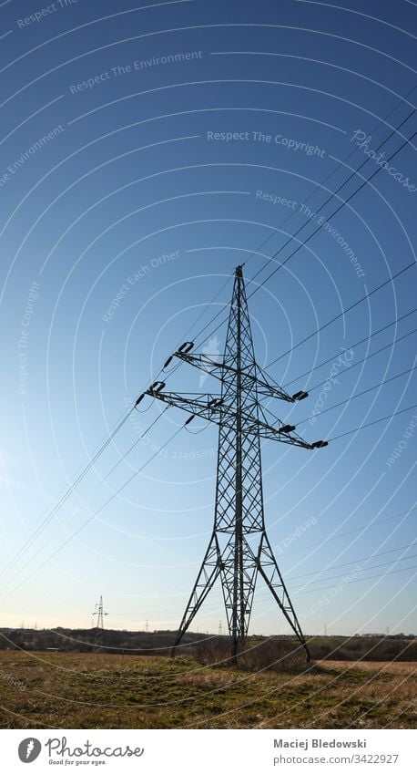 Hochspannungs-Übertragungsmast auf einem Feld gegen die Sonne. Sendemast Industrie Himmel Kraftwerksturm Strommast Energie Kabel Turm elektrisch Elektrizität