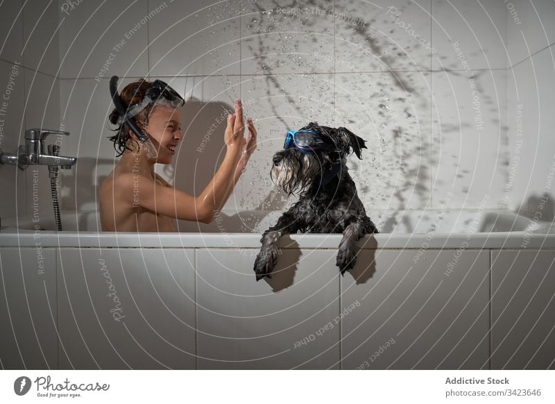 Glücklicher Junge mit seinem Hund in der Badewanne duschend Wasser Dusche Kindheit heimwärts wenig Sauberkeit Kaukasier Lifestyle Hygiene Fröhlichkeit Lächeln