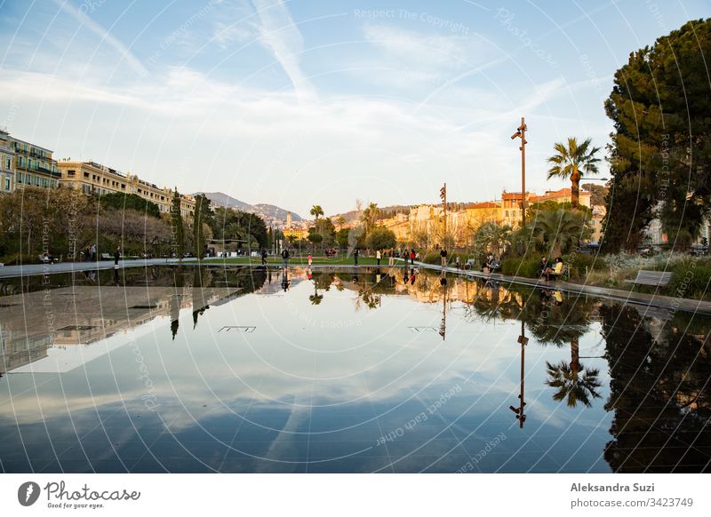 Nizza, Frankreich - 20.03.2018: Springbrunnen auf der Promenade du Paillon, Spiegelungen auf der Wasseroberfläche, Sonnenuntergang. Alpen Architektur Gegend