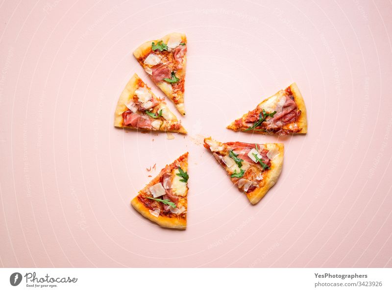Pizzaschinkenscheiben auf rosa Hintergrund. Italienisches Volksgericht Rucola Kohlenhydrate Käse und Schinken Küche Abendessen Essen Europäer berühmt Fastfood