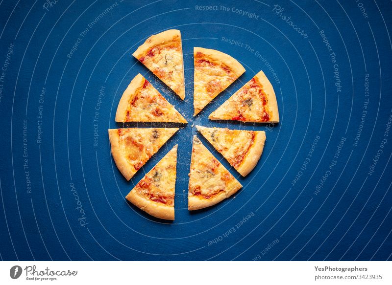 Pizzascheiben auf blauem Hintergrund. 4 Käse-Pizzascheiben 4-Käse-Pizza Italienisch obere Ansicht Kohlenhydrate klassisches Blau Kruste Küche Abendessen