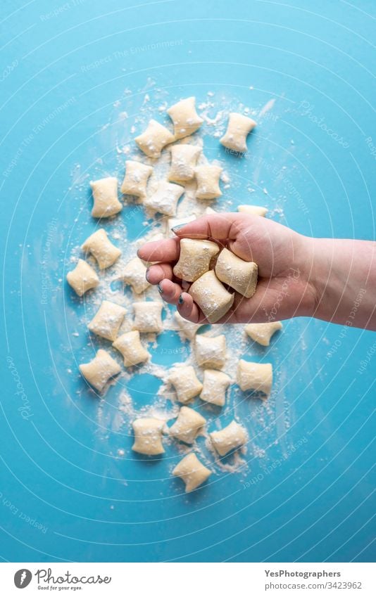 Gnocchi-Knödel ungekocht. Käse-Gnocchi in der Hand Italienisch obere Ansicht blau Essen zubereiten Küche Diät Abendessen Europäer flache Verlegung Mehl