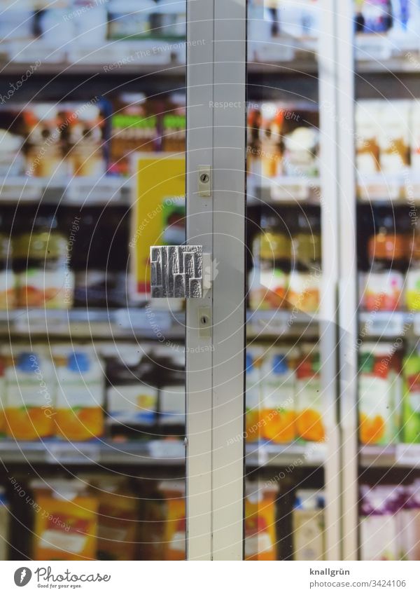 Blick durch die geschlossene Eingangstür eines Supermarktes auf volle Lebensmittelregale Lebensmittelgeschäft Discounter Farbfoto Tür Außenaufnahme Menschenleer