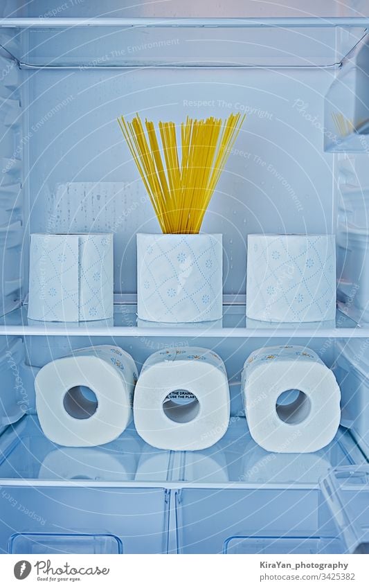Rollen Toilettenpapier und Spaghetti auf Regalen im Kühlschrank als Symbol der Hysterie Coronavirus covid-19 rollen Papier Küche Haushalt Streich Gewebe