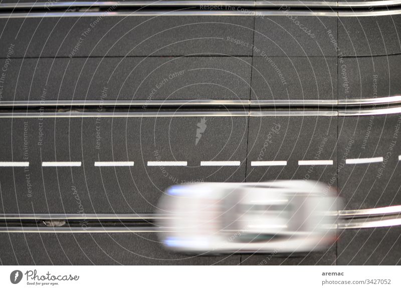 Verwischtes Auto auf einer Modellrennbahn Automobil Rennbahn Carrera Bewegung schwarz weiß Spur Elektro elektrisch Spielzeug Geschwindigkeit Rennwagen